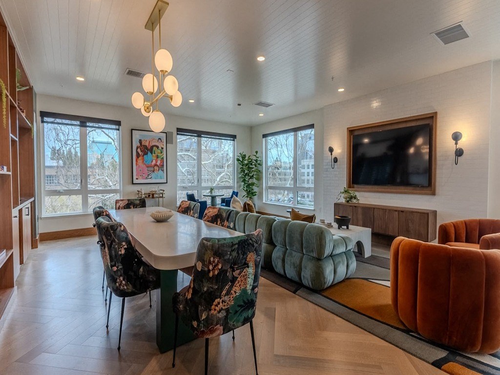 a living room with a large table and chairs and a television