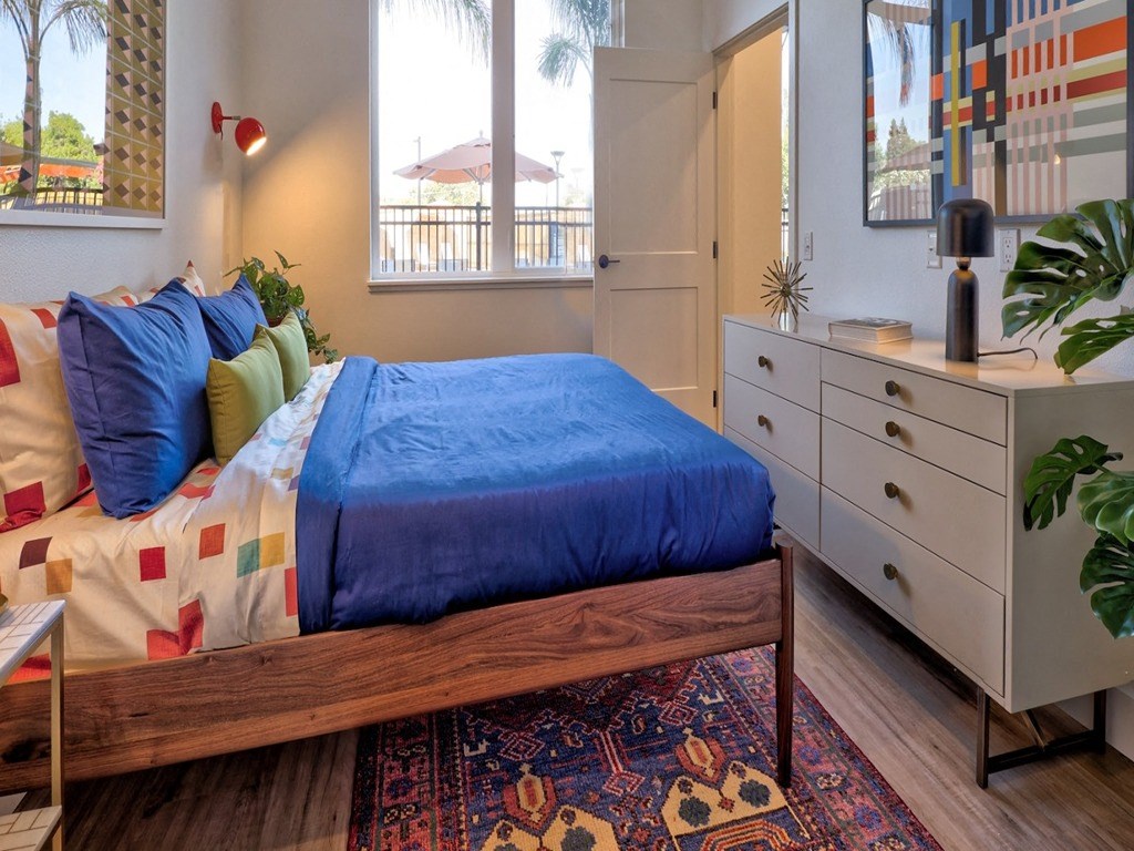 a bedroom with a bed and a dresser and a window