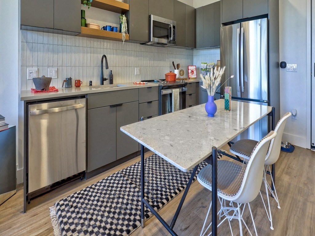 a kitchen with stainless steel appliances and a table with chairs