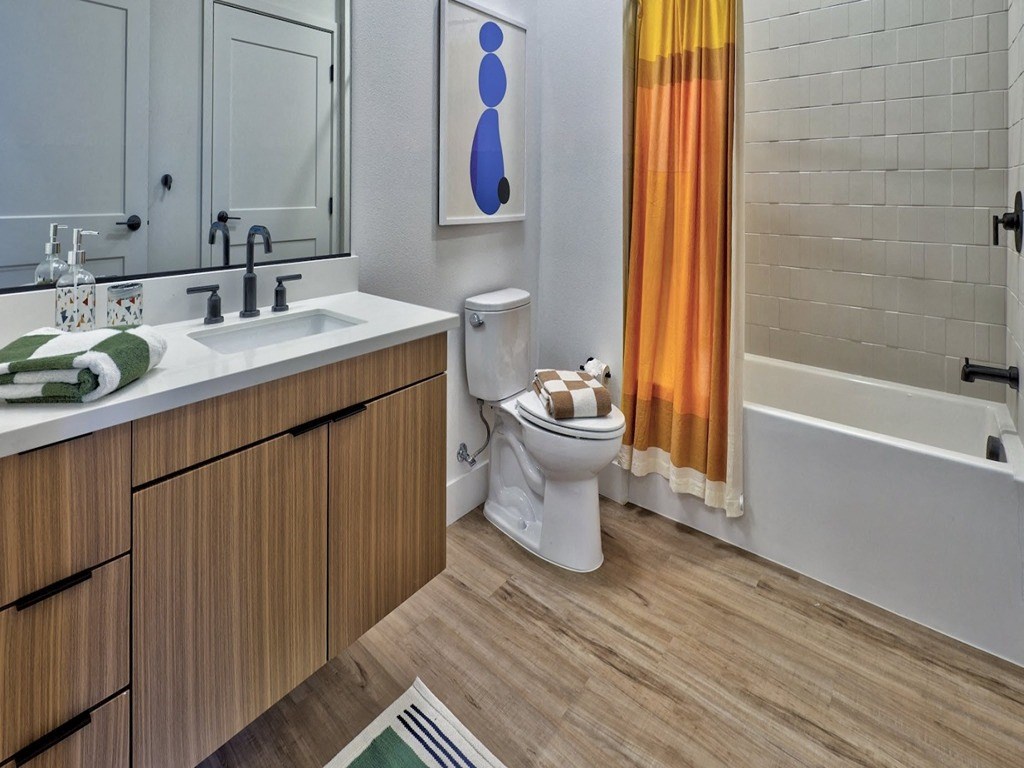 a bathroom with a toilet and a sink and a bath tub