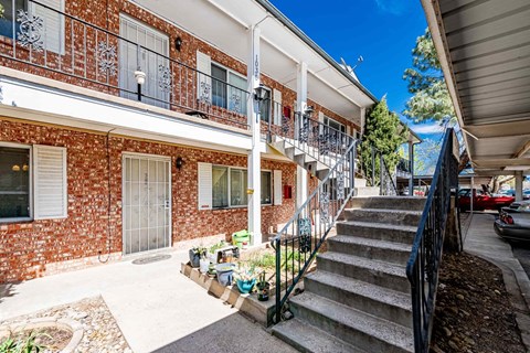 A red brick building with a white door and a balcony.