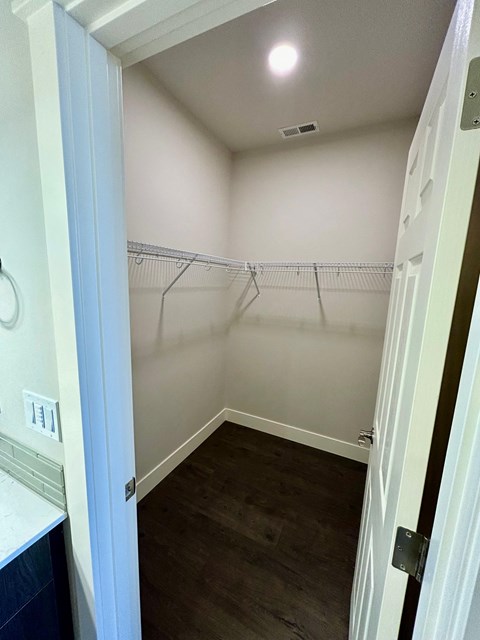 a walk in closet in a bathroom with empty shelves
