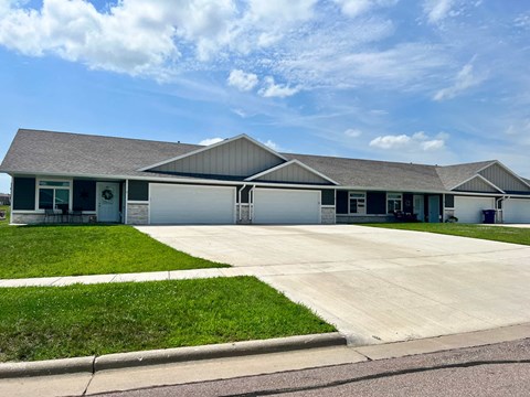 the front of a house with a driveway and grass