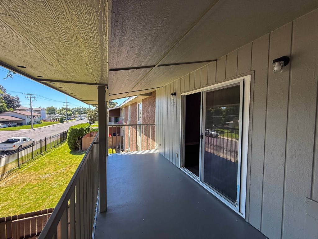 A balcony with a view of a street and cars.