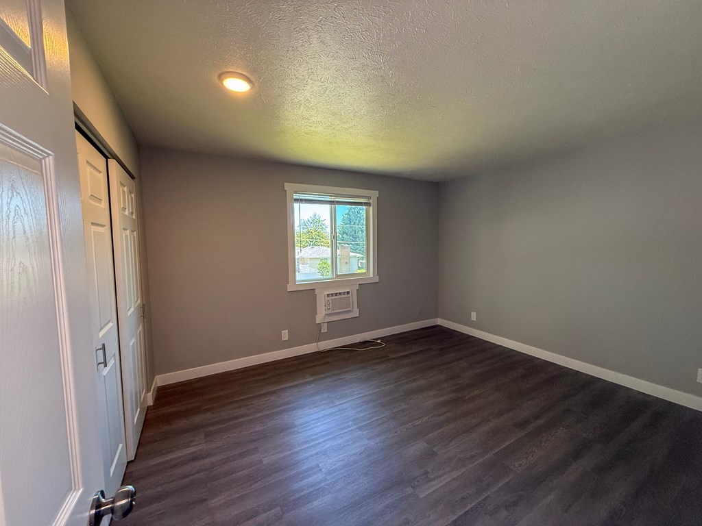 A room with a window and wooden flooring.