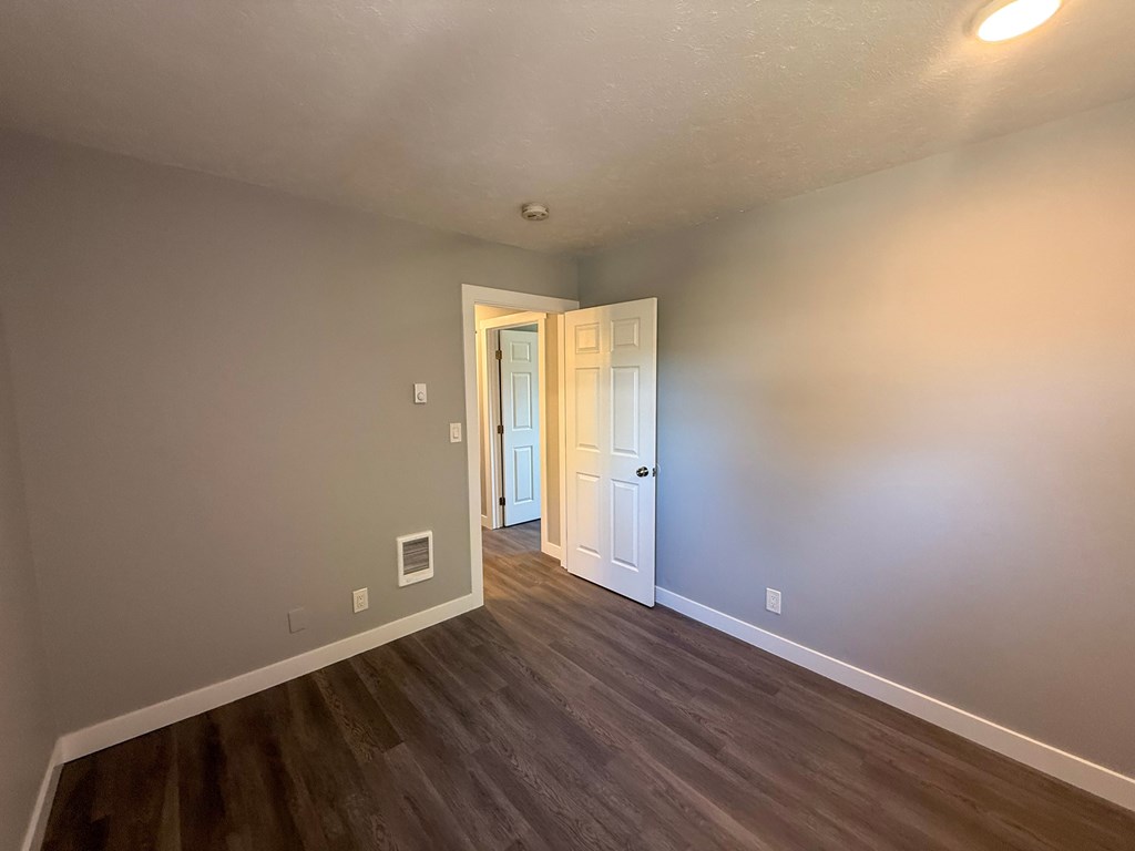 A room with a wooden floor and a white door.