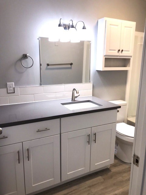 A bathroom with a sink, mirror, and cabinets.