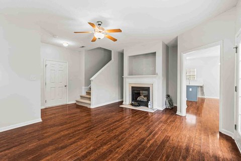 a living room with a fireplace and a ceiling fan