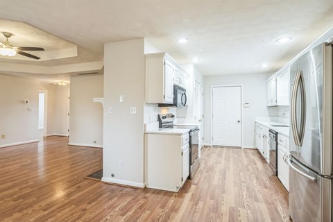 a renovated kitchen with white cabinets and stainless steel appliances
