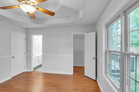 a living room with a large window and a ceiling fan