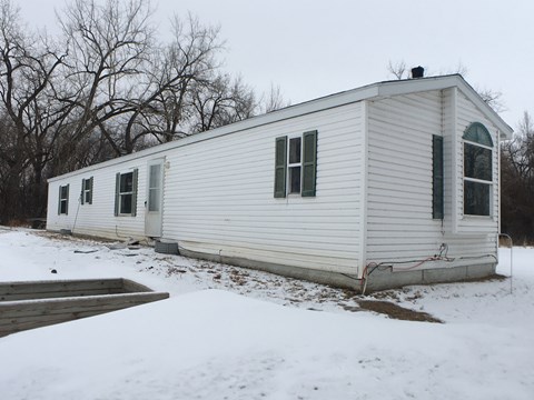 a white house with green shutters in the snow