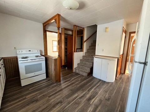 a small kitchen with a stove and a staircase