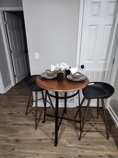 a small dining room with a wooden table and black chairs