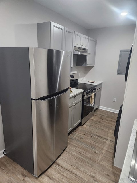 a kitchen with a stainless steel refrigerator and white cabinets