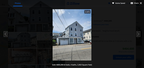 a screenshot of a city street with a blue house and a house on the side