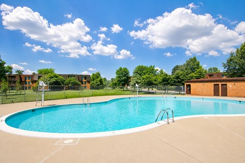 a swimming pool at an apartment complex with a fence around it