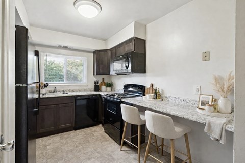 an updated kitchen with black appliances and granite counter tops