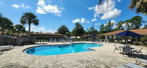a resort style pool with chairs around it and trees