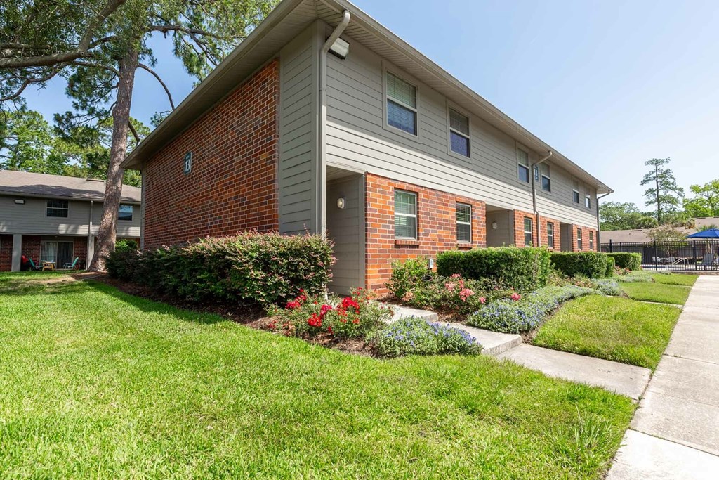 A brick house with a green lawn in front.