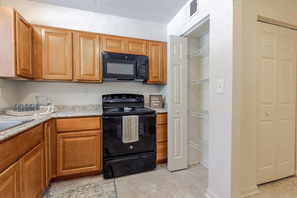 A kitchen with wooden cabinets and a black stove top oven.