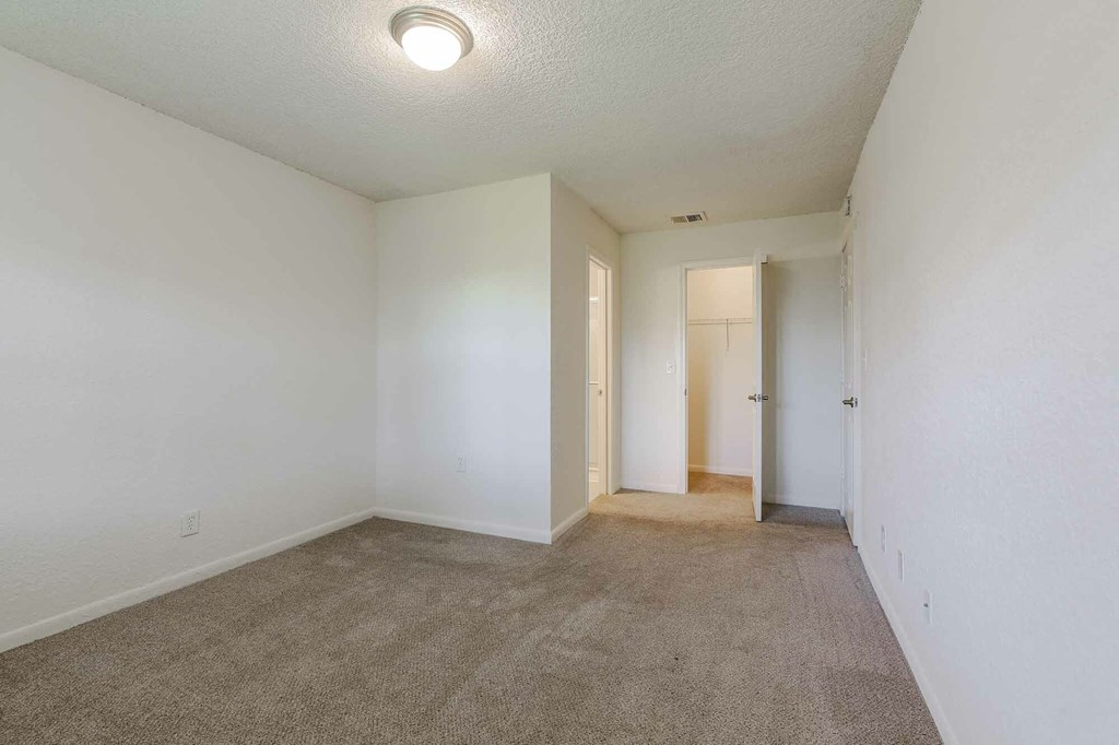 A long hallway with carpeted floors and white walls.