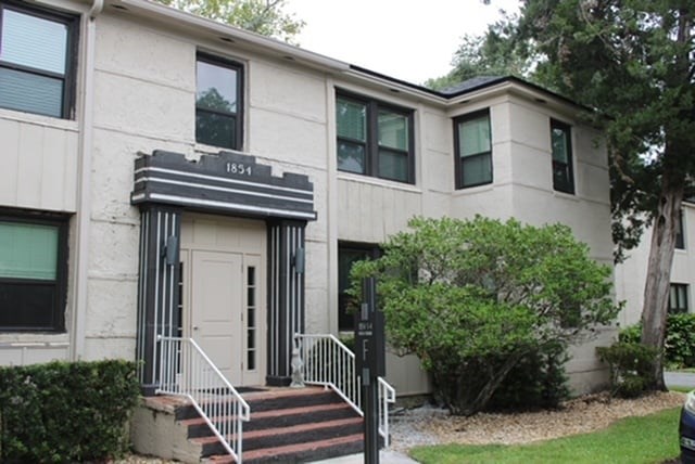 a patio with a fire pit and a table and chairs by the water
