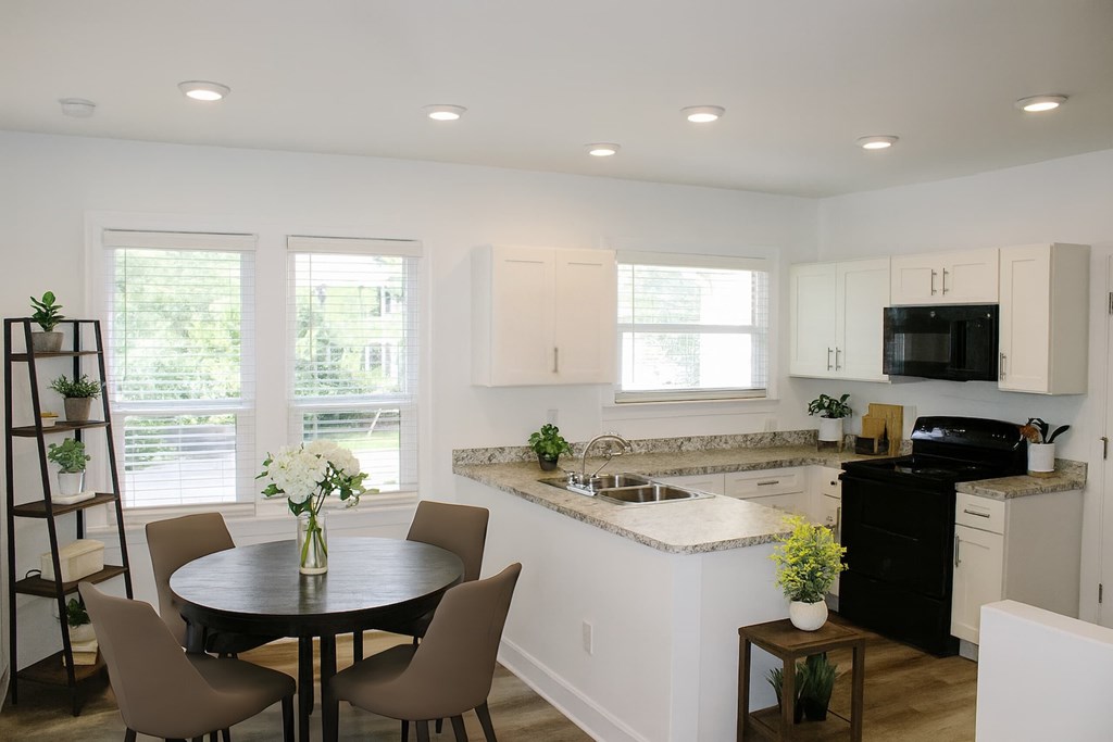 A kitchen with a table and chairs.
