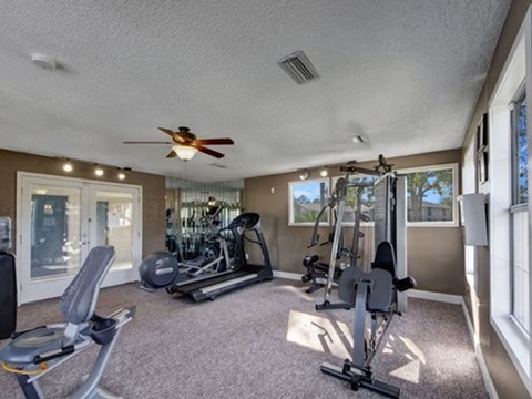 a gym with a ceiling fan and exercise machines