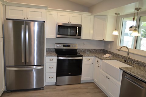 a kitchen with stainless steel appliances and white cabinets