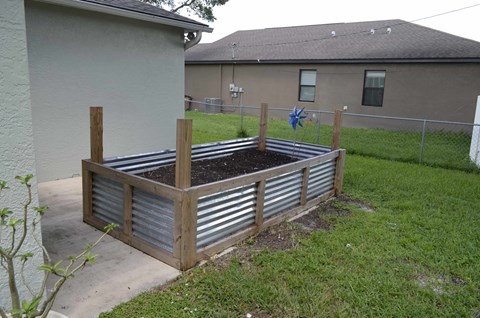 a raised garden with a fence around it