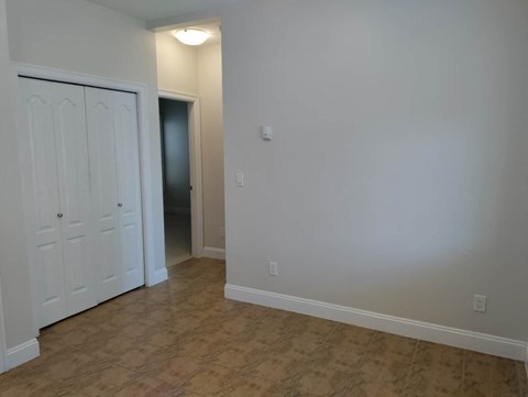 a bedroom with a closet and a door to a hallway
