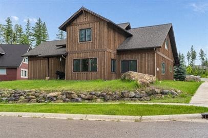 a brown house with a grass yard and a stone wall