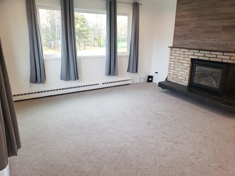 A living room with a fireplace and a large window.