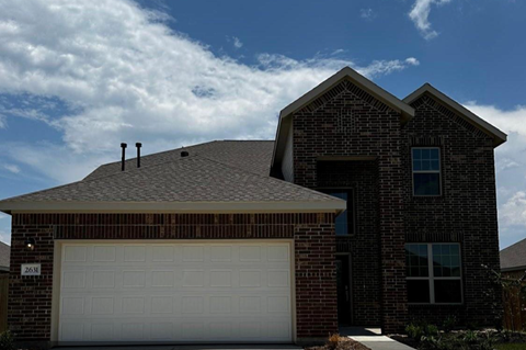 A house with a white garage door and a brick facade.