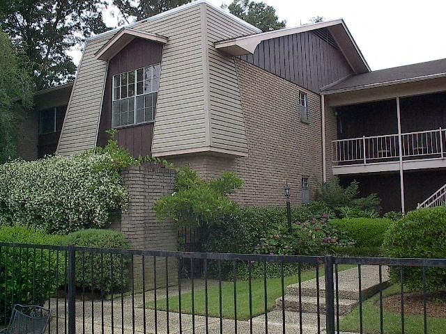 a brick house with a yard and a fence