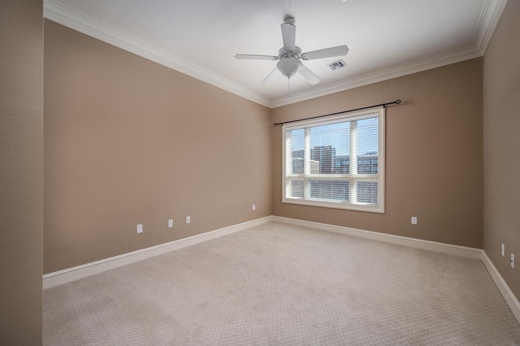 Empty room with a ceiling fan and a window.