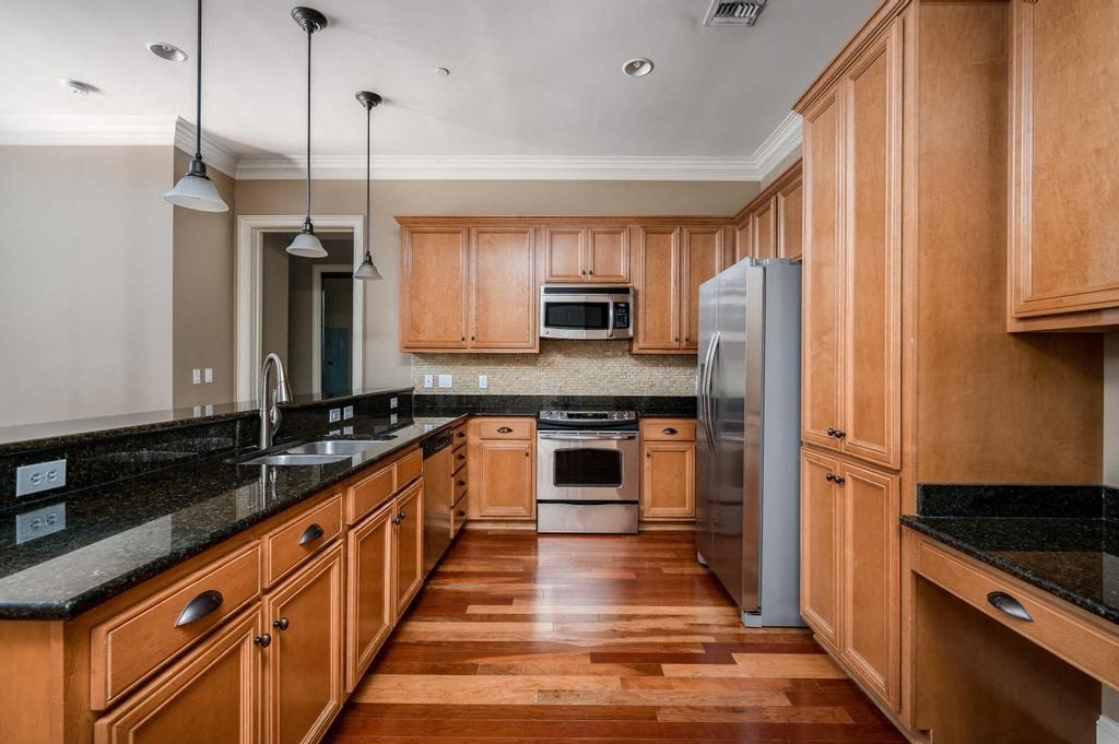 A kitchen with wooden cabinets and a black countertop.