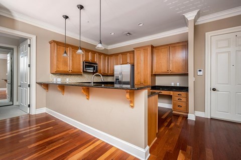A kitchen with wooden cabinets and a black countertop.