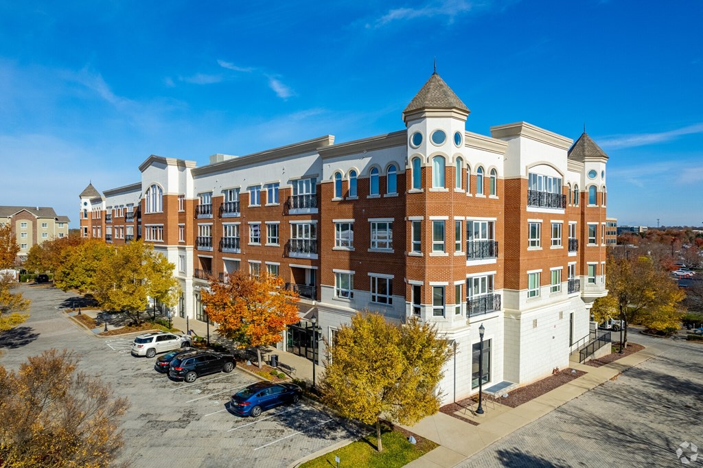 A large, multi-story building with a parking lot in front.