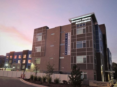 A building with the sign "District North Apartments" on it.