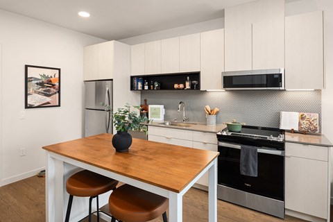 A kitchen with a wooden table and stools.
