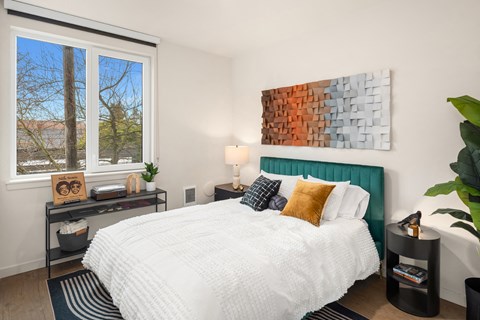 A bedroom with a large bed and a painting on the wall.