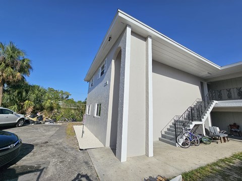 A house with a white exterior and a black metal staircase.