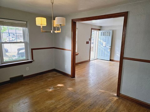 a dining room and living room with wood floors and white walls