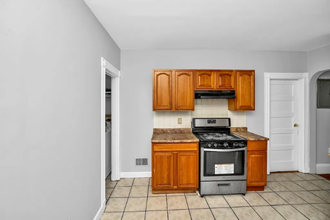 a kitchen with wooden cabinets and a stove top oven