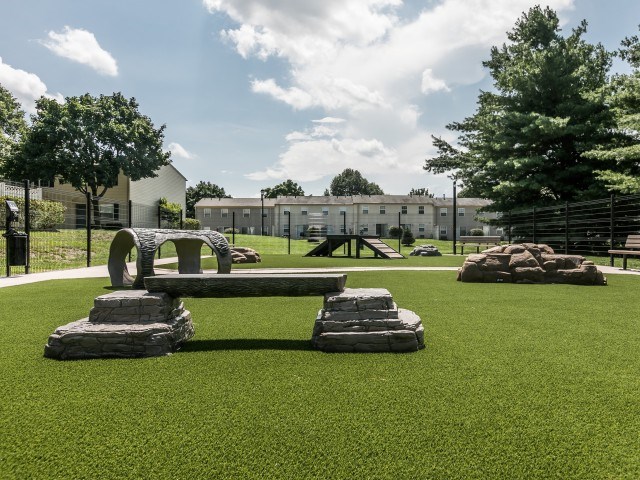 A playground with a slide and a rock climber.