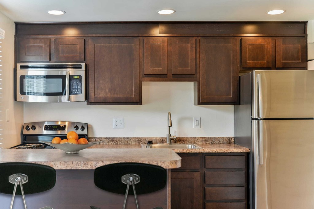 a kitchen with wooden cabinets and stainless steel appliances