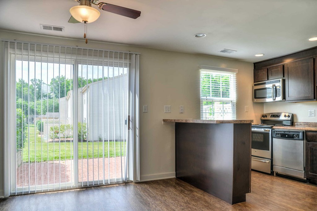 a kitchen with a sliding glass door leading to a backyard
