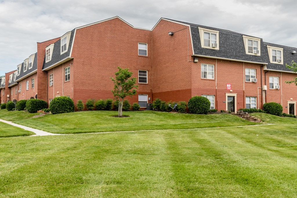 A red brick building with a green lawn in front.
