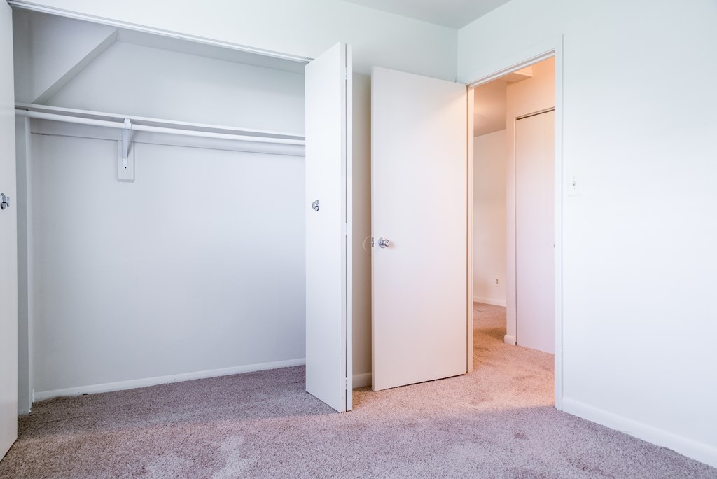 A white door is open to a carpeted hallway.